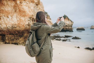 Kız turist Atlantik kıyısında bekleyen bir güzel manzara fotoğrafçılığı bir sırt çantası ile