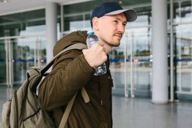 Ya da onu kaldırdı ve bir şişe su elinde tutan bir gezgin bir sırt çantası koyar.