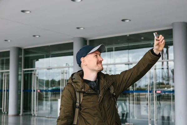 Egy srác egy baseball sapkát vagy egy turista fényképek, vagy nem selfie a telefon. — Stock Fotó