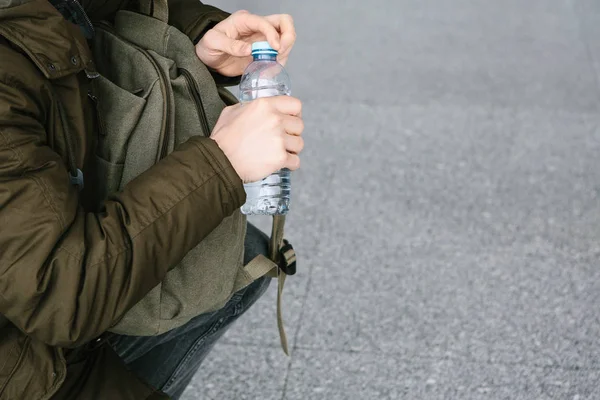 El viajero abre una botella de agua para beber . — Foto de Stock