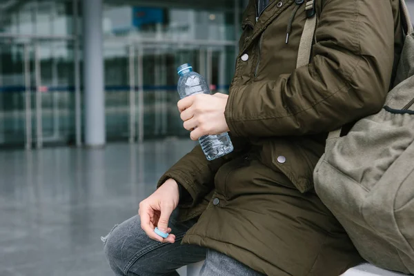 Le voyageur tient une bouteille d'eau dans sa main . — Photo