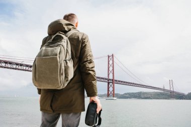 Adam sanal gerçeklik gözlük tutan ve 25 Nisan köprü Lizbon'bakar. Sanal seyahat ve Turizm kavramı. Modern teknolojiler ve bunların kullanımı günlük yaşamda