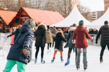 Arka plan bulanık insanlarla açık bir buz pateni pisti üzerinde yolculuk.