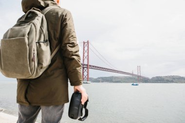 Adam sanal gerçeklik gözlük tutan ve 25 Nisan köprü Lizbon'bakar. Sanal seyahat ve Turizm kavramı. Modern teknolojiler ve bunların kullanımı günlük yaşamda