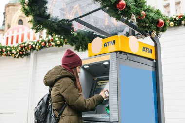 Genç bir kadın bir Atm den para alır.