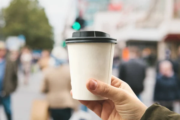 若い女の子が寒い季節のコーヒーまたは他の温かい飲み物と使い捨てガラスを保持します。. — ストック写真