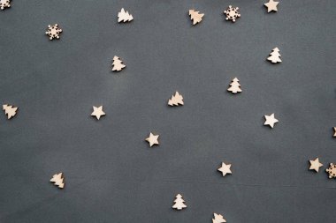 Küçük ahşap Noel ağaçları ve kar taneleri. Şenlikli bir şekilde dekore edilmiş arka plan. Noel ve yeni yıl kavramı minimalist tarzda.
