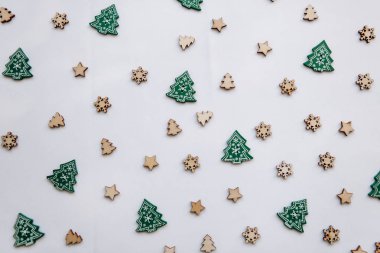 Küçük ahşap Noel ağaçları ve kar taneleri. Şenlikli bir şekilde dekore edilmiş arka plan.