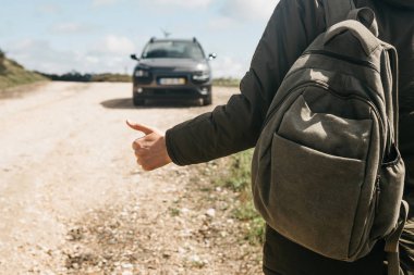 Bir adam uzun yürüyüşe çıkan kimse otostop bir sırt çantası ile yakın çekim.