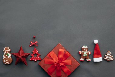 Festival kırmızı bir kutu bir yay ile ve yanındaki Noel süsleri, oyuncak ve gıda çeşitli.