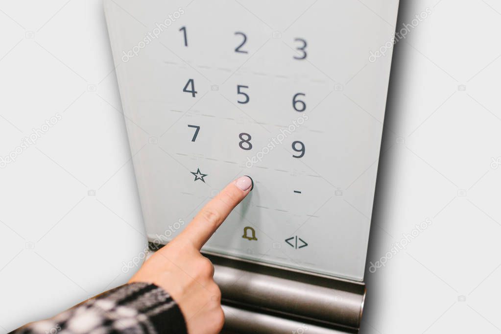 Close-up of a girl pressing a touch button in a modern elevator