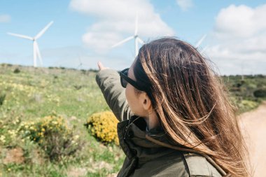 Bir turist yanındaki Portekiz'daki yel değirmenleri.