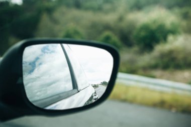 Bir araba arka dikiz aynası bir asfalt yol veya bir otoyol sürüş sırasında bir close-up