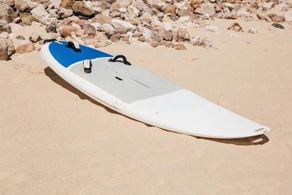 La planche de surf se trouve sur le sable sur la plage — Photo