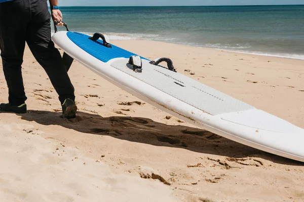 해변에서 서핑 보드를 운반 하는 사람 — 스톡 사진