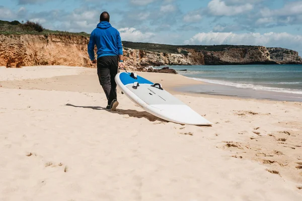 Člověk nese surfu na pláži — Stock fotografie