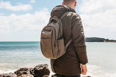 Turist veya gezgin Atlantik kıyısında bir sırt çantası ile