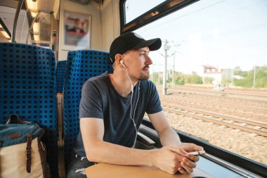 Genç bir adam bir müzik veya podcast bir tren seyahat ederken dinler