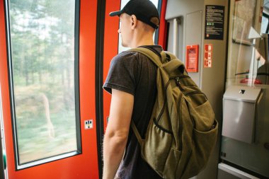 Turist adam veya treni durdurmak bekleyen bir sırt çantası ile öğrenci