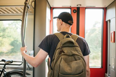 Turist adam veya treni durdurmak bekleyen bir sırt çantası ile öğrenci