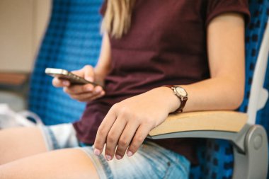 Trende bir turist bir cep telefonu kullanır.