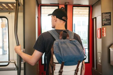 Turist adam veya treni durdurmak bekleyen bir sırt çantası ile öğrenci