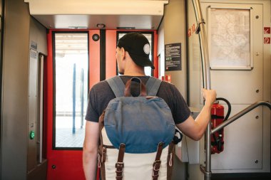 Turist adam veya treni durdurmak bekleyen bir sırt çantası ile öğrenci