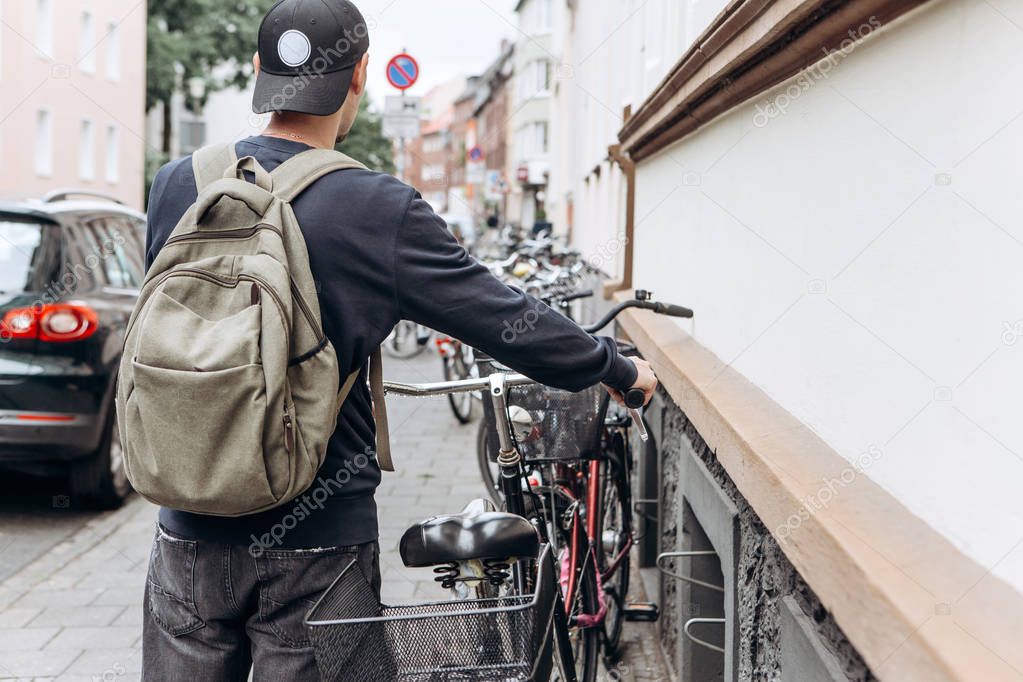 Tourist or student with a backpack is going to ride a bike