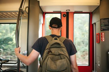 Turist adam veya treni durdurmak bekleyen bir sırt çantası ile öğrenci
