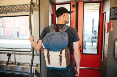 Turist adam veya treni durdurmak bekleyen bir sırt çantası ile öğrenci
