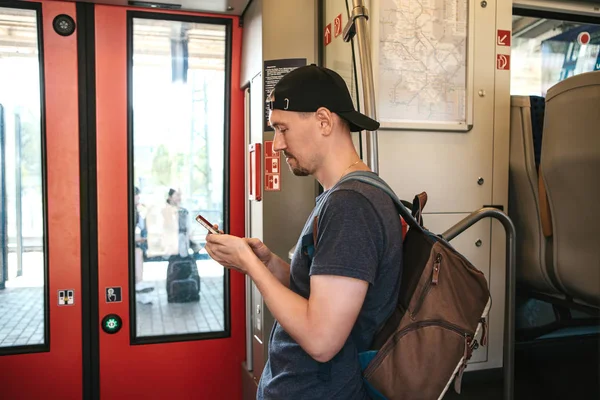 Un turista en el tren utiliza un teléfono móvil . — Foto de Stock