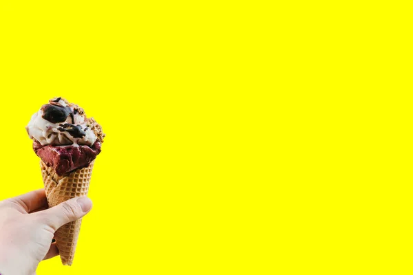 The girl is holding a delicious ice cream in her hand in a minimal style on a pink background. Summer concept