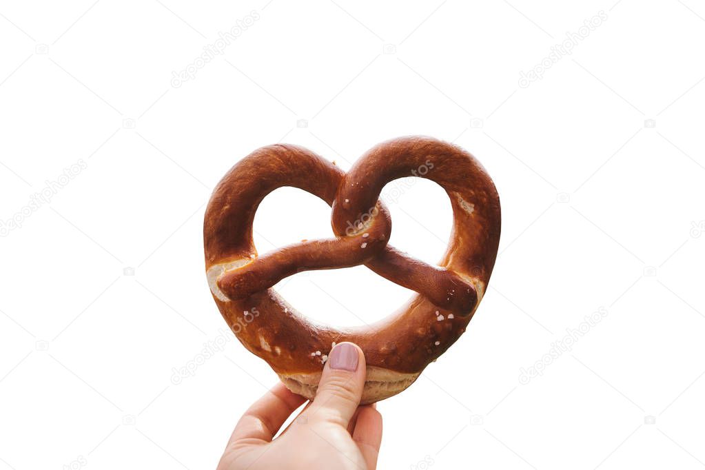 Traditional German pretzel in hand isolated on white background