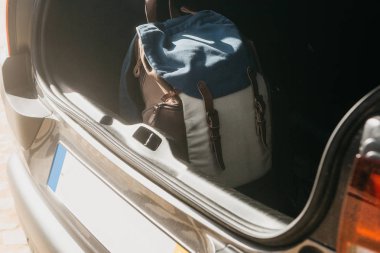 Bir arabanın bagajında sırt çantası. Yolculuk için hazırlık. Turizm ya da araba ile seyahat kavramı