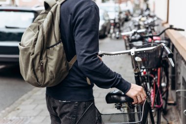 Turist veya öğrenci bir sırt çantası ile bir bisiklet gidiyor
