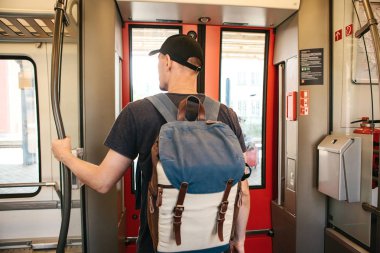 Turist adam veya treni durdurmak bekleyen bir sırt çantası ile öğrenci