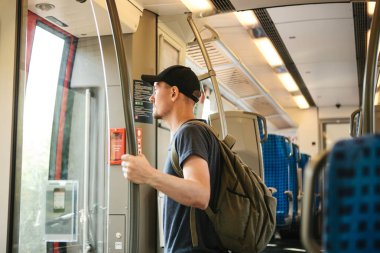 Turist adam veya treni durdurmak bekleyen bir sırt çantası ile öğrenci