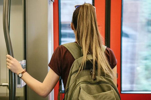Chica turística o estudiante con una mochila esperando a que el tren se detenga para salir — Foto de Stock