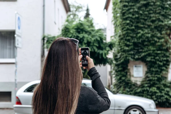 La chica en la calle toma fotos de los hermosos edificios — Foto de Stock