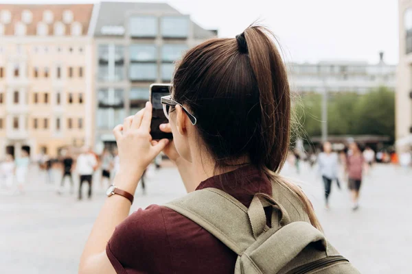 La chica en la calle toma fotos de los hermosos edificios — Foto de Stock