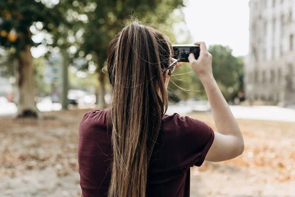 La chica en la calle toma fotos de los hermosos edificios — Foto de Stock