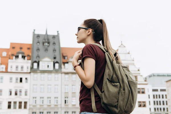 Turistické dívka s batohem v Lipsku obdivovat krásné budovy. — Stock fotografie