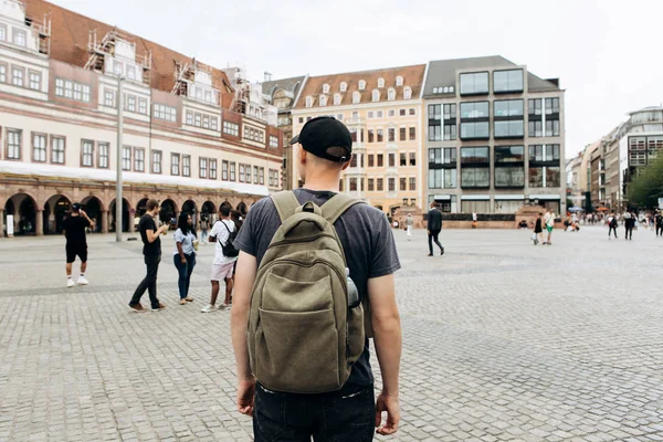 Turistické muž s batohem v Lipsku obdivovat krásné budovy. — Stock fotografie