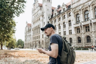 Bir turist erkek veya çocuk bir sırt çantası ile bir cep telefonu kullanır