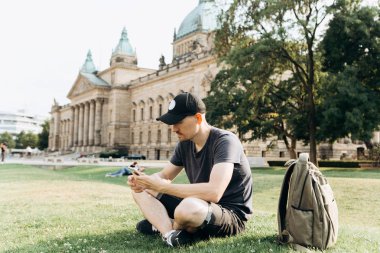 Bir turist erkek veya çocuk bir sırt çantası ile bir cep telefonu kullanır