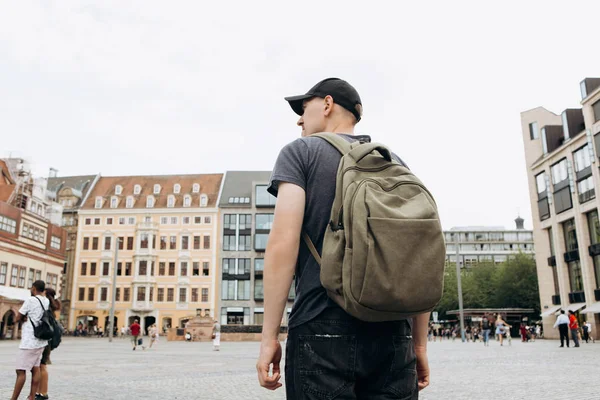 Turistické muž s batohem v Lipsku obdivovat krásné budovy. — Stock fotografie