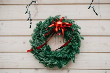 Kırmızı yay üzerinde ahşap arka plan asılı ile Noel çelenk