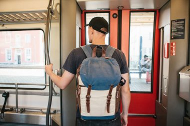 Turist adam veya treni durdurmak bekleyen bir sırt çantası ile öğrenci