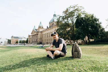 Bir turist erkek veya çocuk bir sırt çantası ile bir cep telefonu kullanır