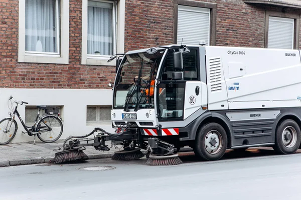 Un camión especial o vehículo de limpieza viaja a lo largo de la carretera y limpia la calle de suciedad y polvo . —  Fotos de Stock